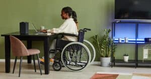 blaock woman in wheelchair working on desk