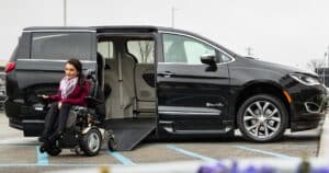 woman in wheelchair smiling near Chrysler Pacifica wheelchair van